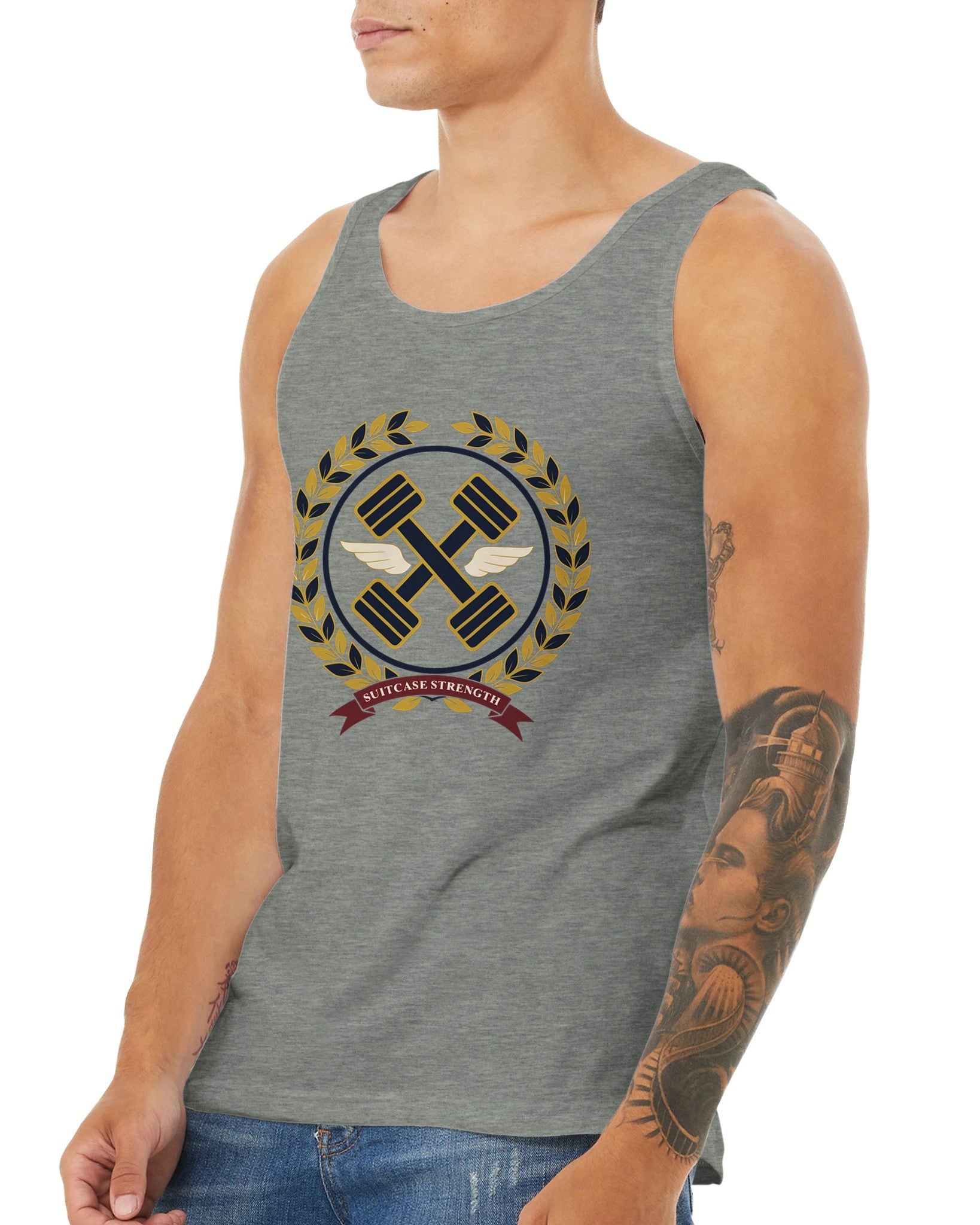 Suitcase Strength unisex premium tank top for travelling professionals, printed with a gold laurel-wreath crest with navy crossed dumbbells, cream aviator wings and a SUITCASE STRENGTH ribbon — product photo 18 of 18