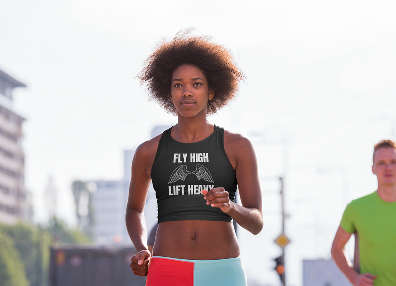 Woman running outdoors in the Fly High Edition Layover Crop Top by Dumbbells and Hotels — layover-ready travel activewear for women who train on the road