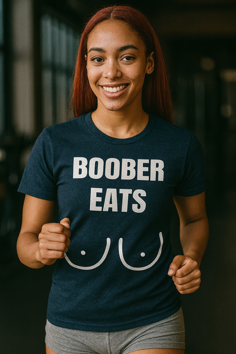 Young athletic African-American woman with red straight hair jogging in a gym while wearing a navy “Boober Eats” Bella + Canvas 3001 t-shirt and grey shorts; ideal fitness apparel for traveling professionals like flight attendants, pilots, and nurses.

