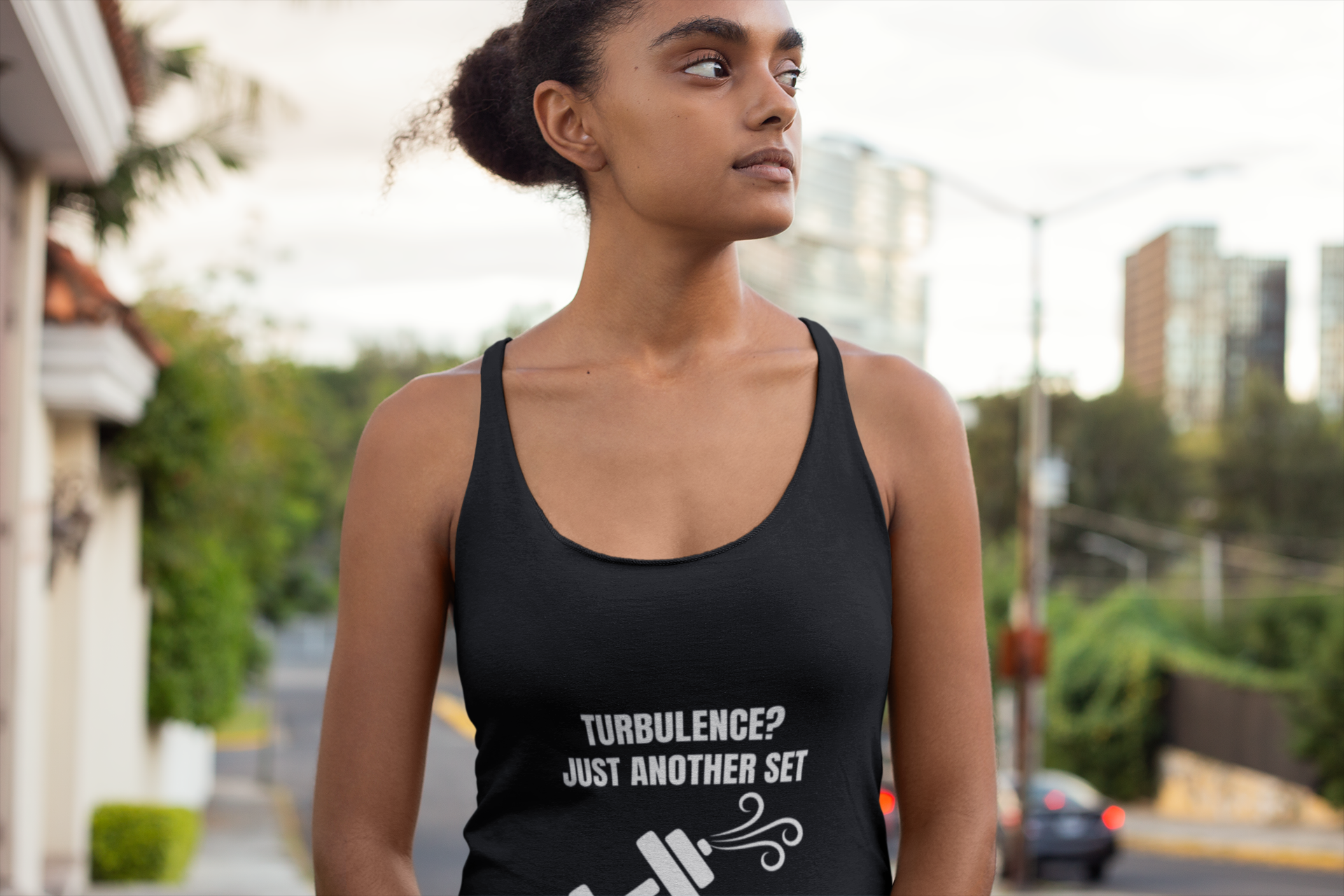 Female travel professional wearing wrinkle-resistant Turbulence racerback tank on urban street - designed by pilots
