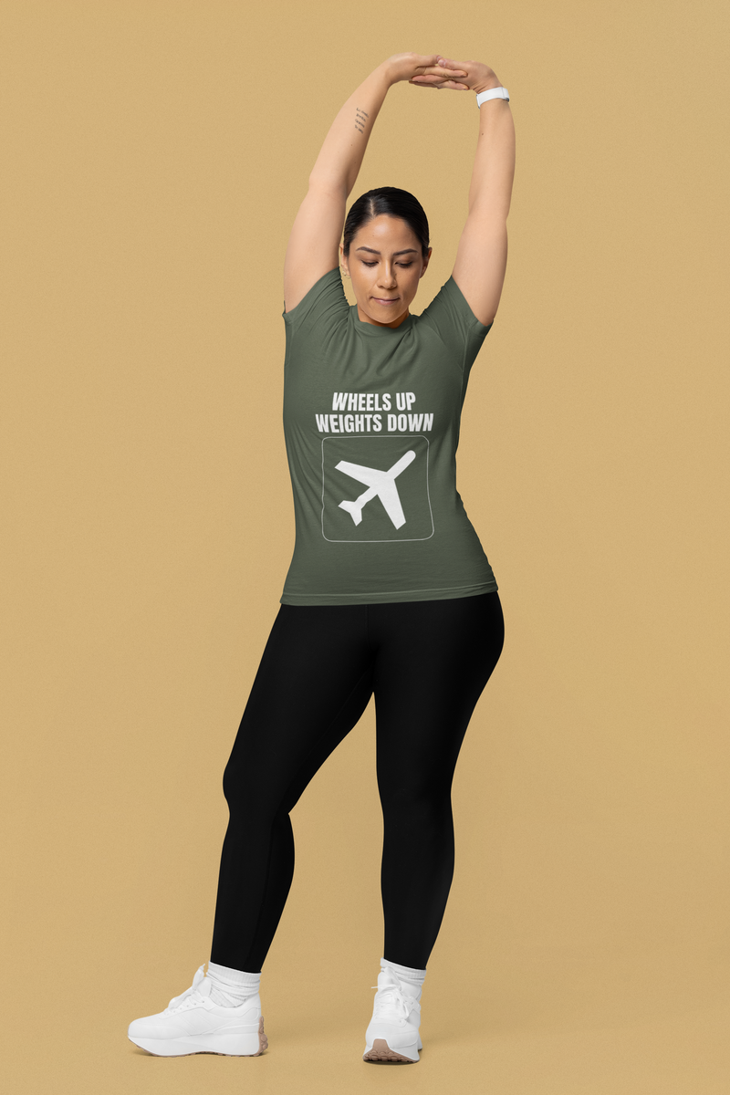 Woman stretching overhead in military green Wheels Up Weights Down travel gym t-shirt, travel nurse and corporate consultant fitness apparel