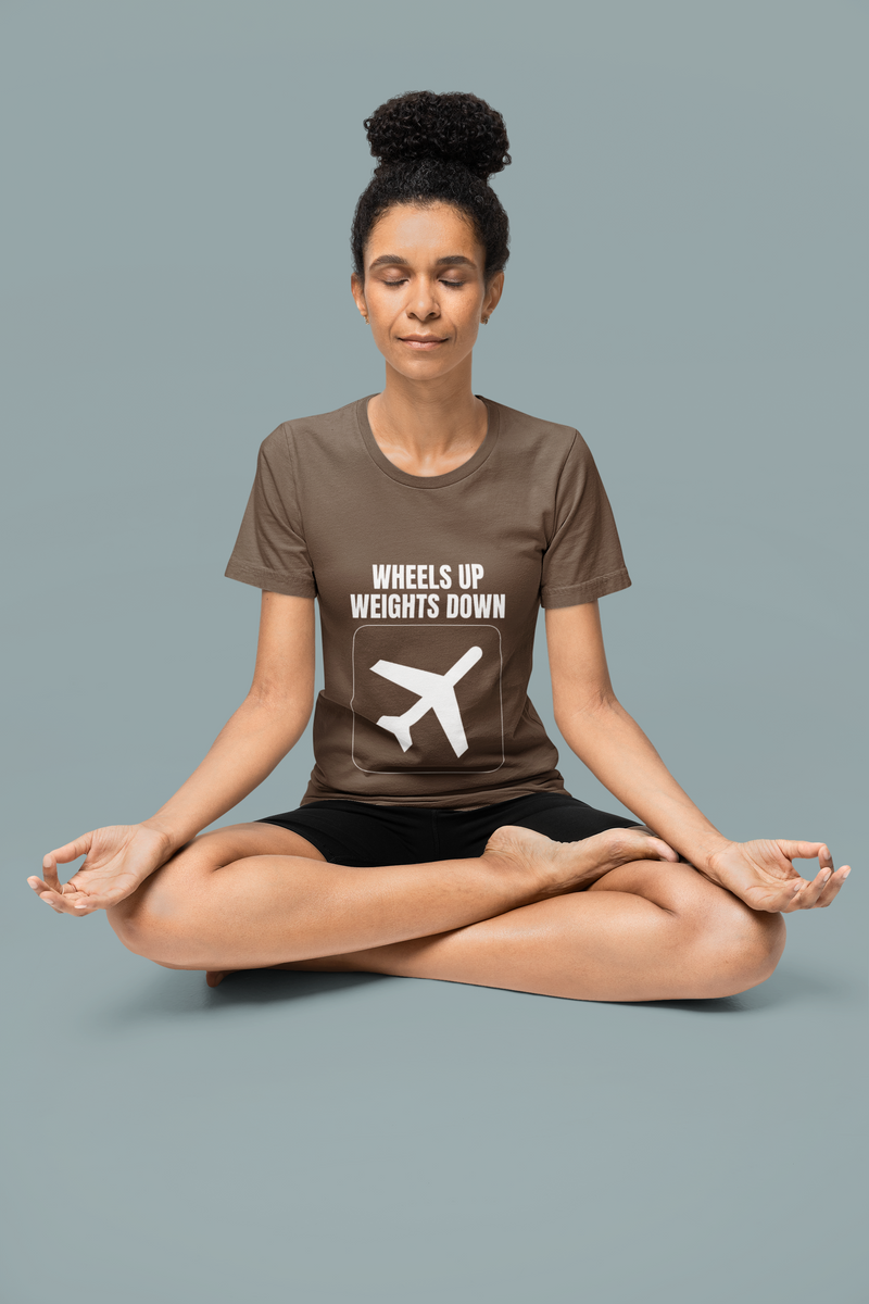 Woman in meditation pose wearing brown savana Wheels Up Weights Down travel gym t-shirt, veteran-founded premium travel fitness apparel